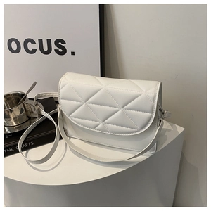 Detail showing white quilted PU leather shoulder bag with triangle pattern on white podium