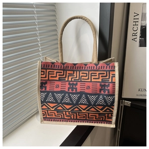 Detail shot of a bohemian jute tote bag with ethnic patterns and thick rope handles