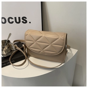 Close-up of geometric quilted texture on beige leather crossbody flap bag