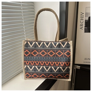 Detail view of ethnic geometric pattern tote bag with rustic woven jute rope handles
