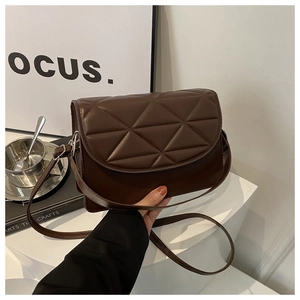 Detail of deep brown quilted shoulder bag with minimalist triangular geometric stitching