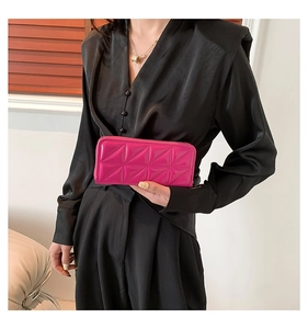Detail of fuchsia geometric quilted long wallet with glossy finish and zip closure