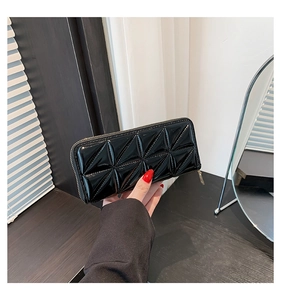 Detail of a black long zipper wallet featuring a glossy quilted diamond texture finish