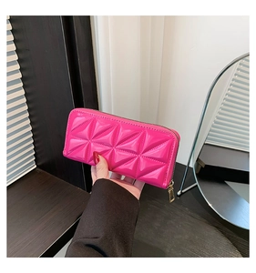 Pink quilted patent leather wallet with gold zipper detail and pyramid texture