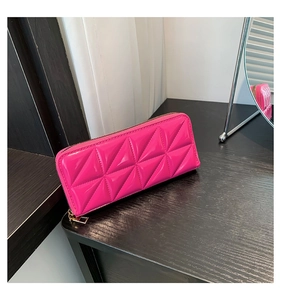 Detail view of pink long wallet with 3D geometric quilted pattern and gold zipper