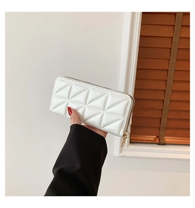 Detailed view of white quilted faux leather wallet with geometric triangle pattern and zipper