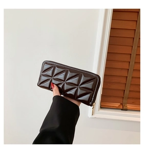 Close-up of brown patent leather long wallet with quilted triangle texture and gold zipper