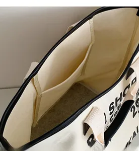 Detail shot of the spacious interior compartment and inner pocket of this canvas tote bag