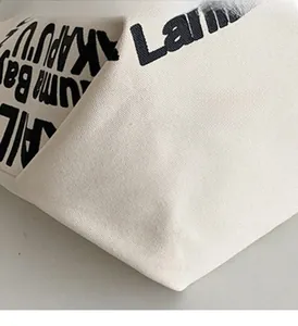 Detail view of durable canvas bag with black letter print and premium stitching seams