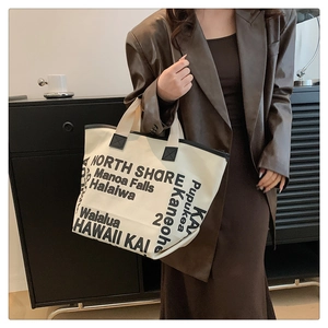 Détail du grand sac cabas en toile beige avec imprimé noir et poignées renforcées
