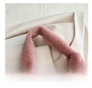 Close-up of pink plush handbag showing soft texture and silver metal zipper detail
