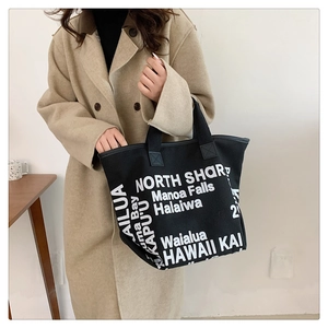 Détail d'un sac cabas en toile noire avec des inscriptions Hawaii blanches élégantes