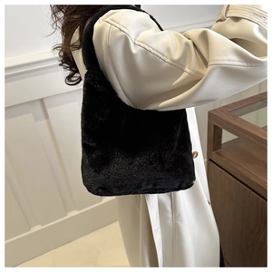 Close-up of black faux fur tote bag with plush texture shown on a female model