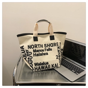 Détail du sac cabas en toile avec bordure noire et imprimé typographique de Hawaii