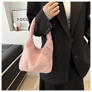 Close-up of pink plush handbag in soft faux fur texture with elegant handle details