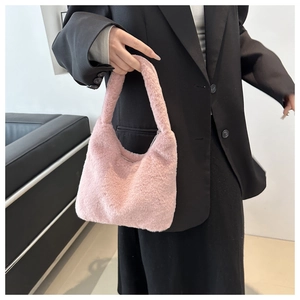 Pink faux fur plush handbag with soft texture and top handle carried by a model