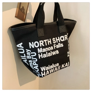 Détail du sac cabas en toile noire montrant l'imprimé Hawaii et les coutures de l'anse