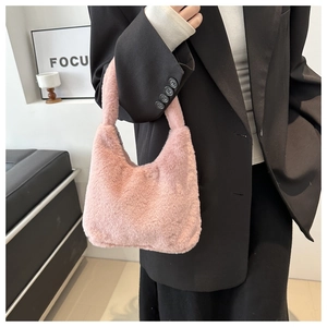Detail of pink faux fur crescent handbag showing soft fluffy texture on black blazer background