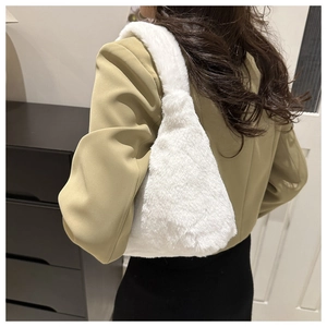 Detail view of large white plush shoulder bag worn by model for autumn winter style