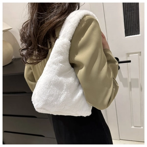 Detail of soft white faux fur shoulder bag worn by model in a minimalist home setting