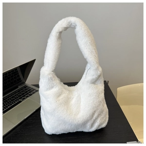 Close-up of white plush faux fur hobo handbag with silver metal zipper on an office desk