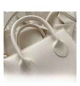 Detail view of smooth cream leather handbag handle with precision stitching accents