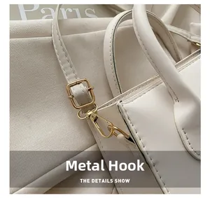 Detail showing high-quality gold metal hook and buckle on minimalist cream crossbody bag