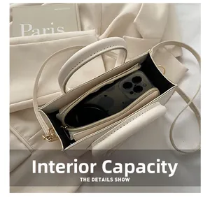 Internal capacity of beige crossbody bag showing space for phone and wallet with gold hardware