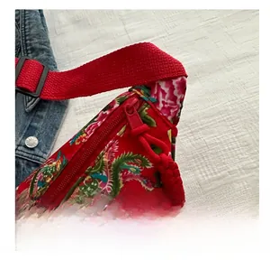 Makro-Detail der roten Ethno-Tasche mit Blumenmuster, glattem Reißverschluss und Phoenix-Print