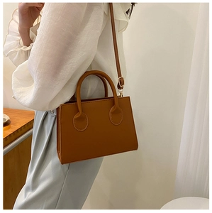 Sac à main carré marron porté par un mannequin pour montrer la taille et l'effet réel
