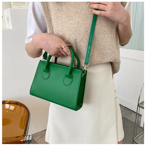 Détail du mini sac structuré vert avec ferrures dorées et poignées de transport rondes