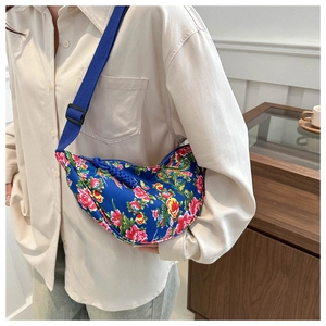 Detailansicht der blauen halbmondförmigen Umhängetasche mit traditionellem Blumenmuster