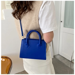 Detail of Klein Blue rectangular handbag showing smooth PU texture and adjustable shoulder strap