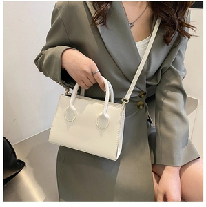 Close-up of minimalist beige PU leather small crossbody bag with dual top handles