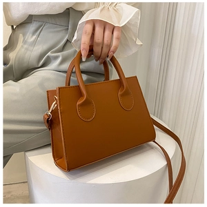 Detailed shot of brown vintage crossbody bag featuring smooth faux leather and gold hardware
