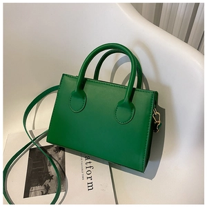 Detail of vintage green crossbody bag with textured leather and gold metal hooks