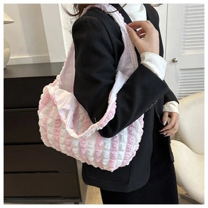 Detail of pink and white striped pleated tote bag with a soft bubble texture finish