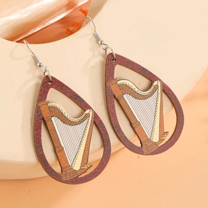 Détail de boucles d'oreilles en bois en forme de goutte avec motif harpe sur céramique