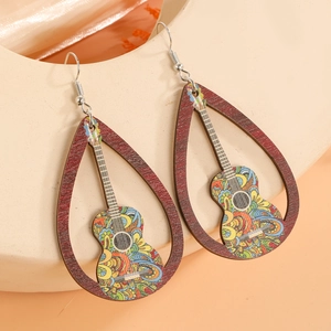 Gros plan de boucles d'oreilles en bois en forme de goutte avec motif guitare