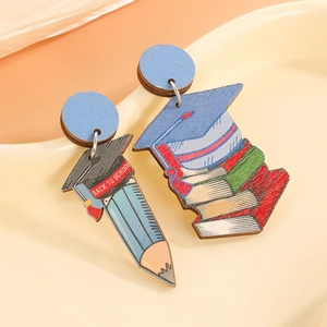 Detail asymmetrischer Holzohrringe mit Motiven von Bleistift und Büchern zum Schulanfang
