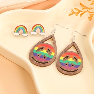 Rainbow cloud studs and wooden peace sign teardrop earrings set displayed on a tray