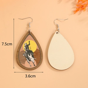 Detail of teardrop wooden earrings featuring black and white western cowboy rodeo print