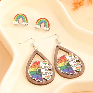 Close-up of wooden rainbow earrings with Love is Love print on a display tray