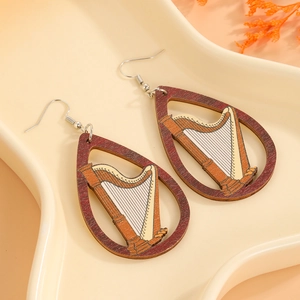 Détail de boucles d'oreilles en bois en forme de goutte avec motif harpe ajouré