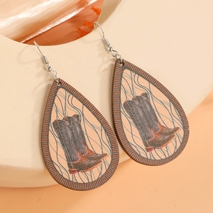 Detail of teardrop wooden earrings featuring retro cowboy boot print and metal hooks