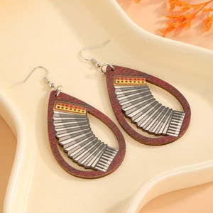 Gros plan de boucles d'oreilles en bois en forme de goutte avec motif accordéon