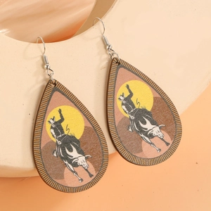 Detail of teardrop wooden earrings featuring retro western cowboy rodeo printing