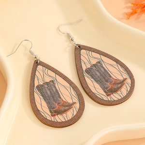 Detail of wooden teardrop earrings with western cowboy boot print on ceramic tray