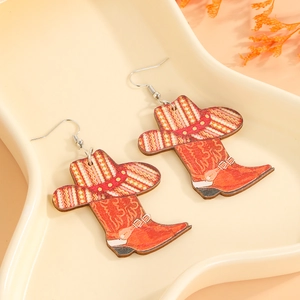Detailed close-up of Western cowboy boot and hat drop earrings on a ceramic tray