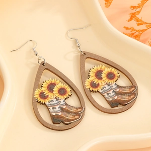 Detail shot of wooden teardrop earrings with sunflower and cowboy boot design